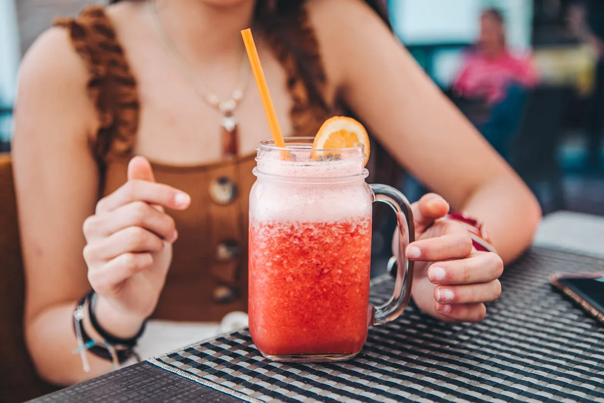 young tourist drinking strawberry smoothie