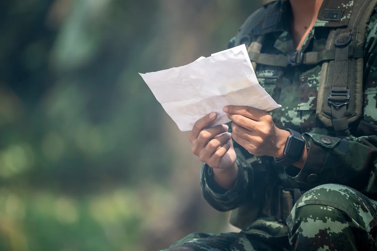 Female soldier reading letter among war