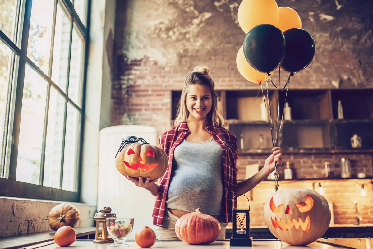Pregnant woman with Halloween pumpkin