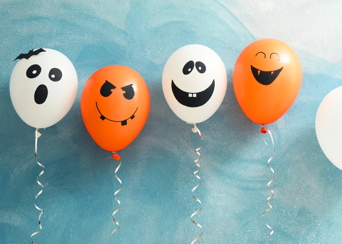 Halloween balloons on color background