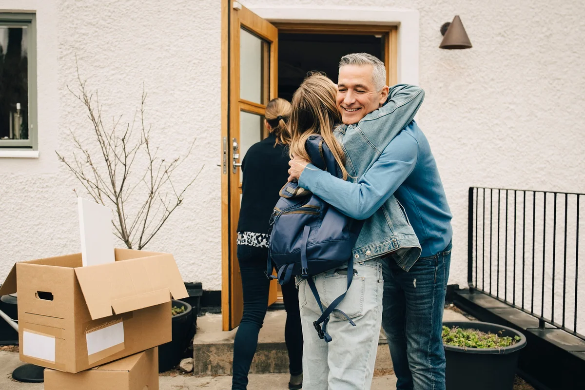 Happy father hugging daughter while standing at back yard