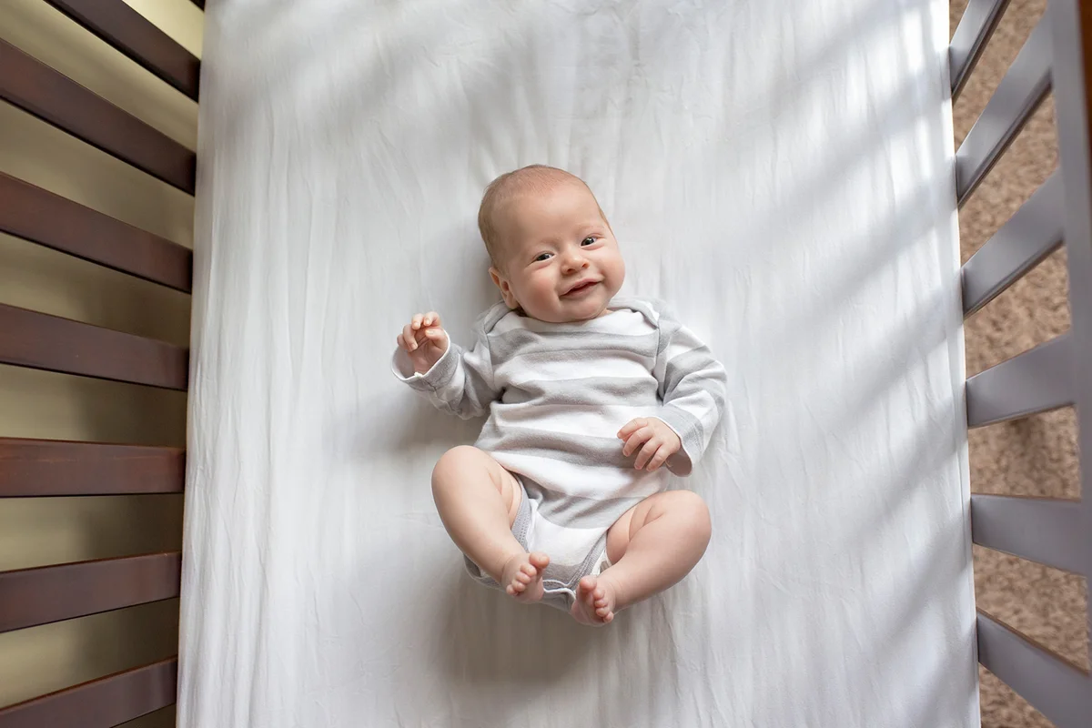 Overhead portrait of baby boy in crib at home
