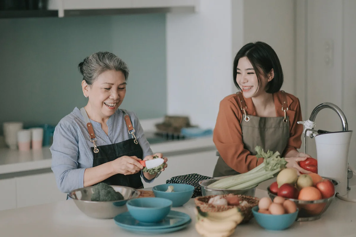Woman and her mother getting ready cooking meals