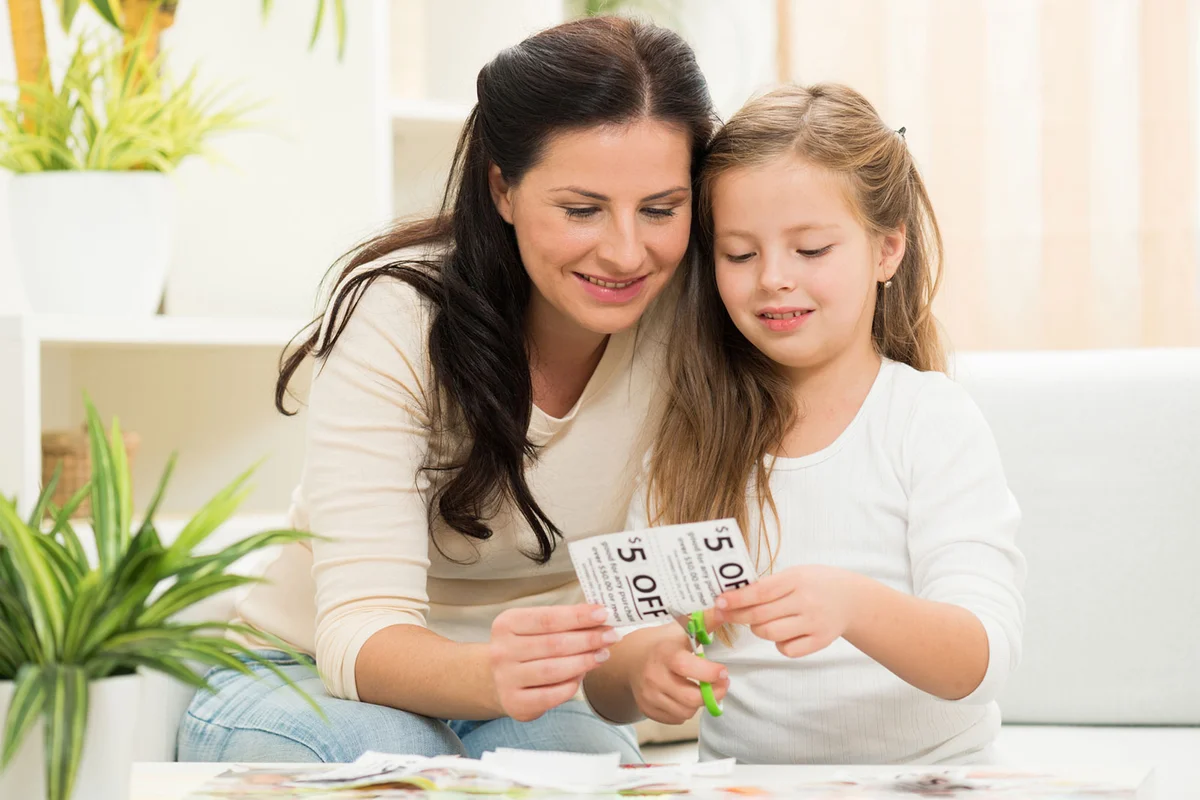 mother and daughter clipping coupons