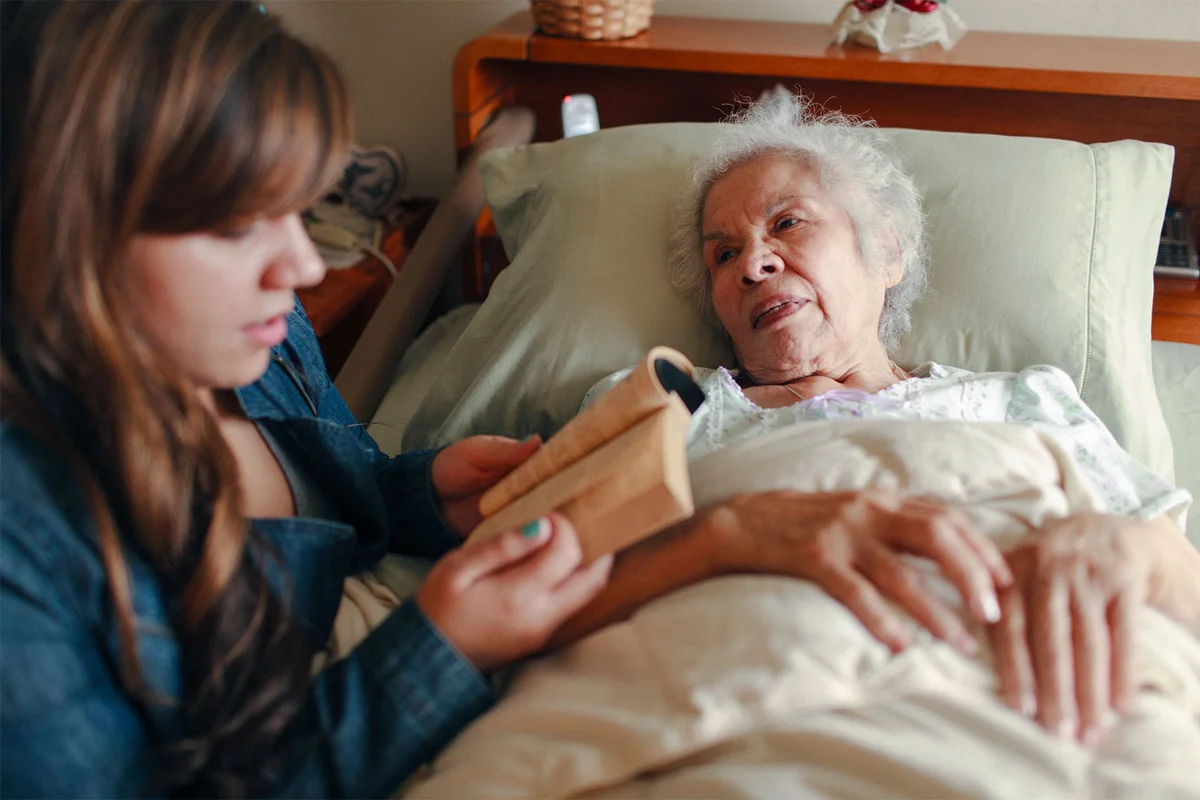 granddaughter reading to dying grandmother