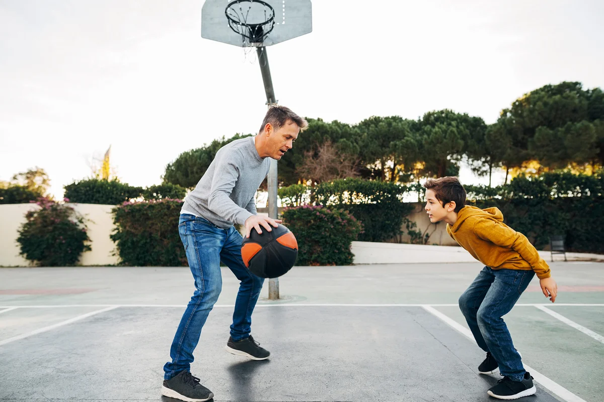 Men and boy playing basketball