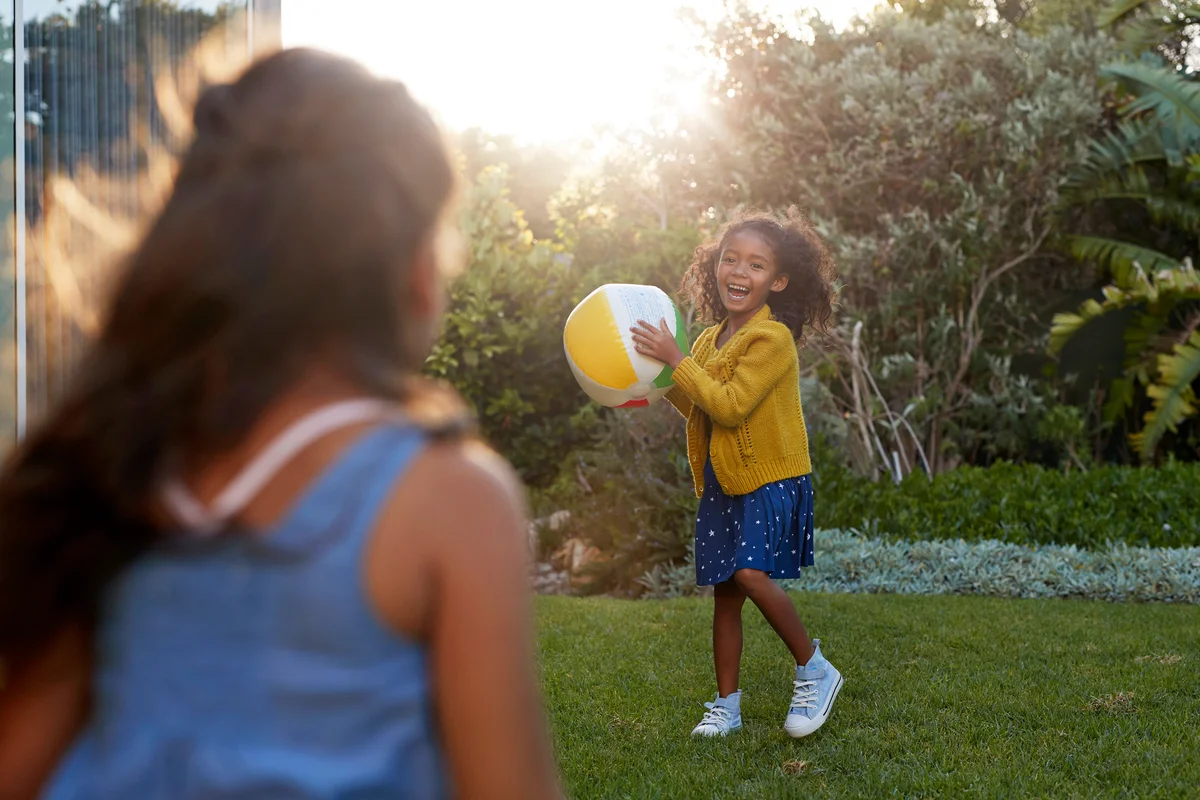 Family playing with ball in the garden