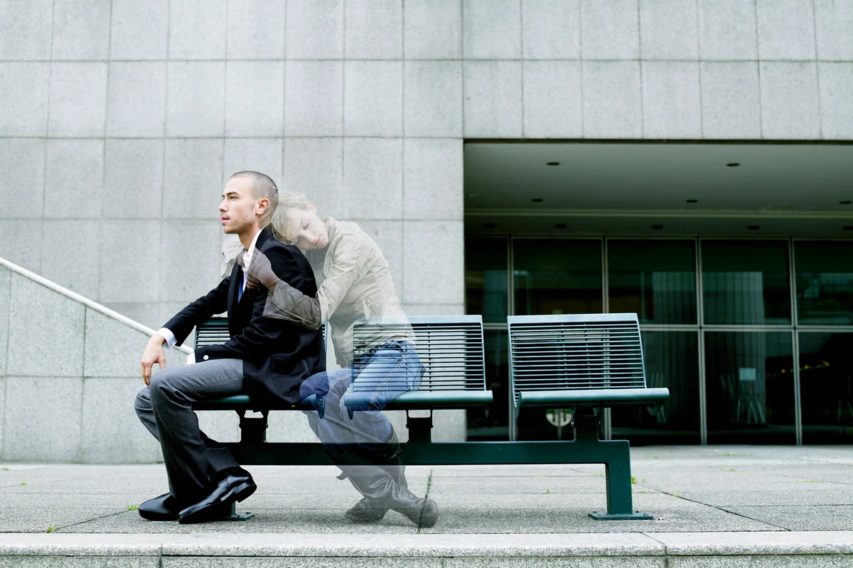 Ghost of woman embracing young man on bench