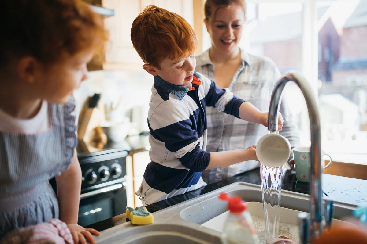 Two children and their Mother washing the dishes