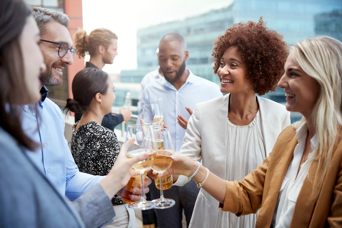 Office colleagues raising glasses and making a toast with drinks after work