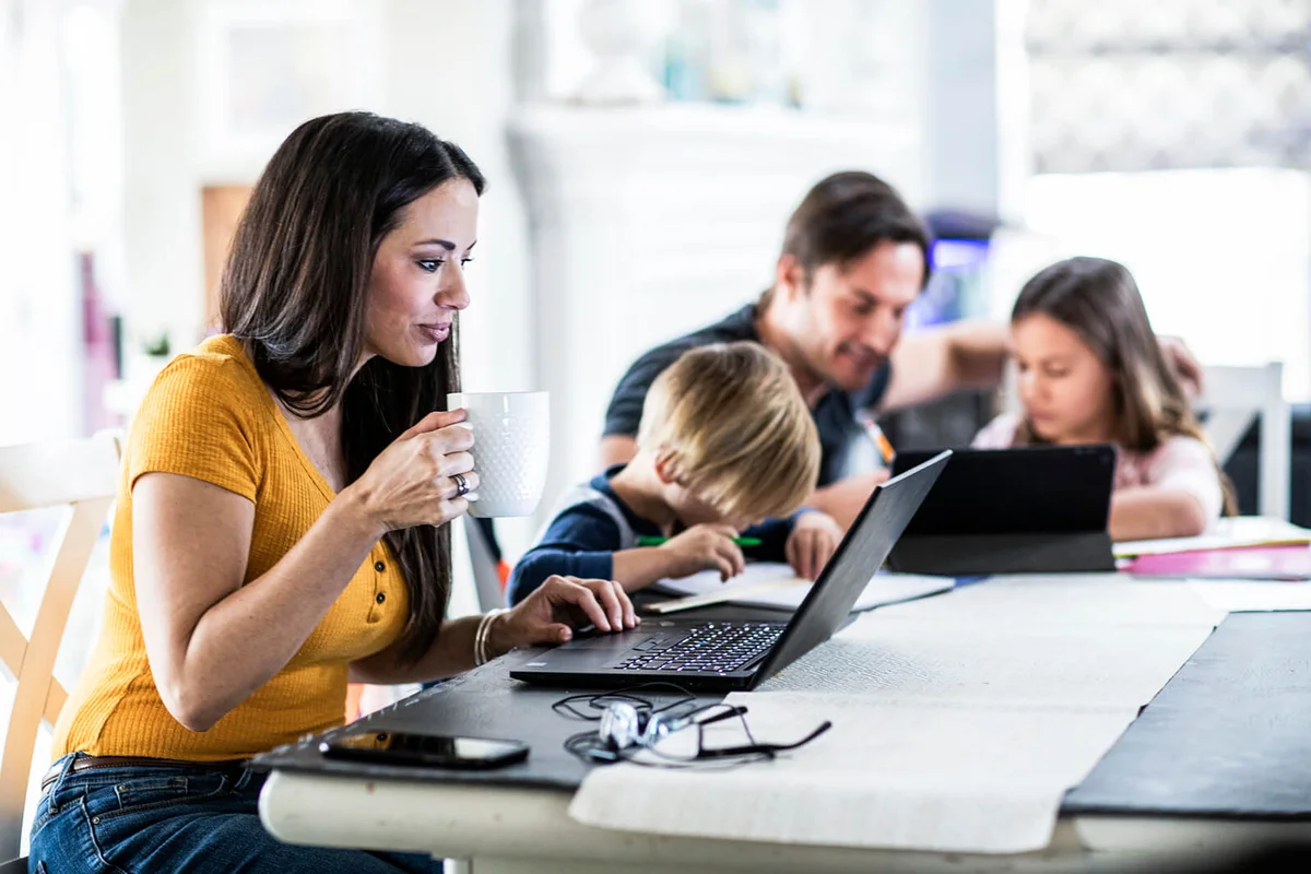 Mother working from home while children attend school online