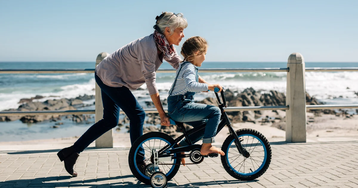 Grandmother teaching granddaughter to ride a bike