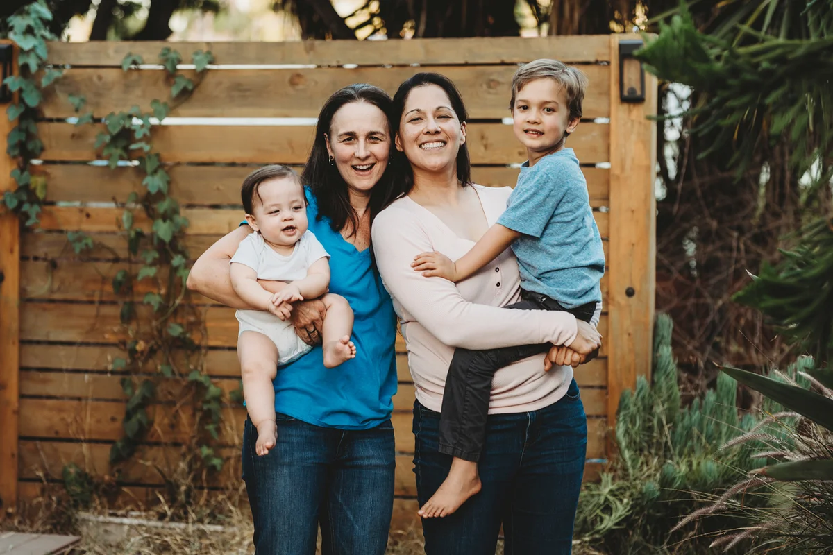 Happy family outdoors with two moms & two kids
