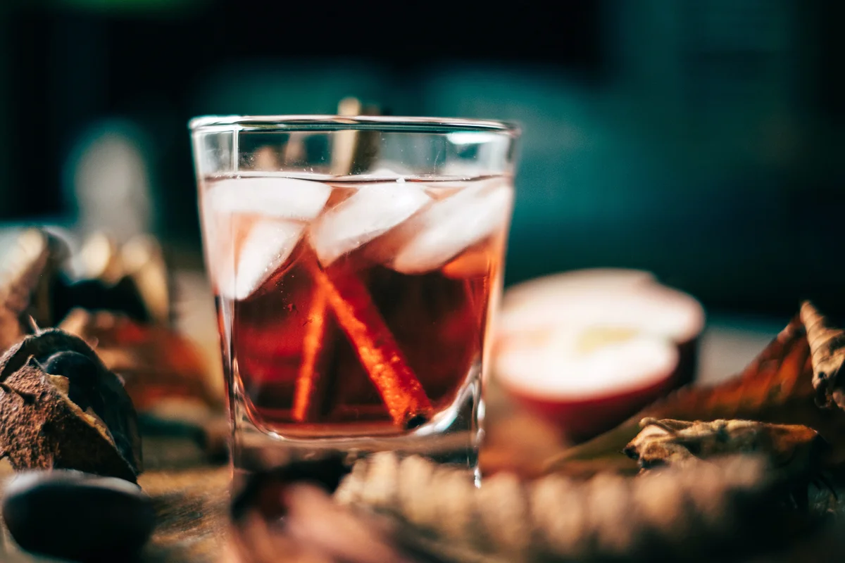Apple cider cocktail with cinnamon sticks