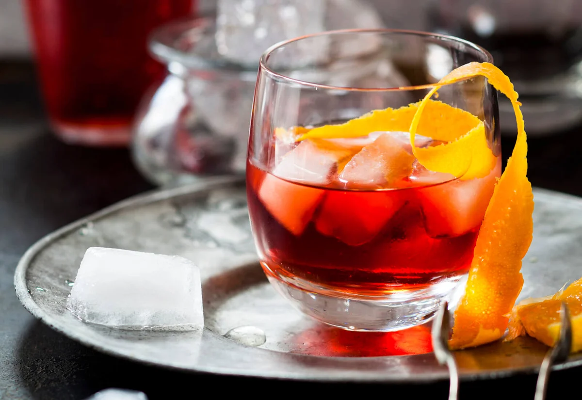 Negroni with orange peel and ice cubes