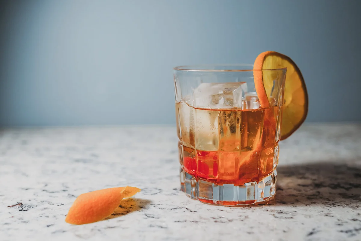 old fashioned cocktail garnished with orange slice