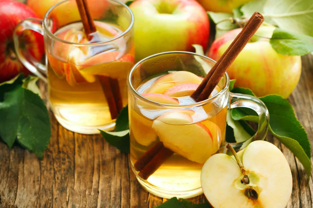 Two Apple Pie Toddy with apples on a wood table