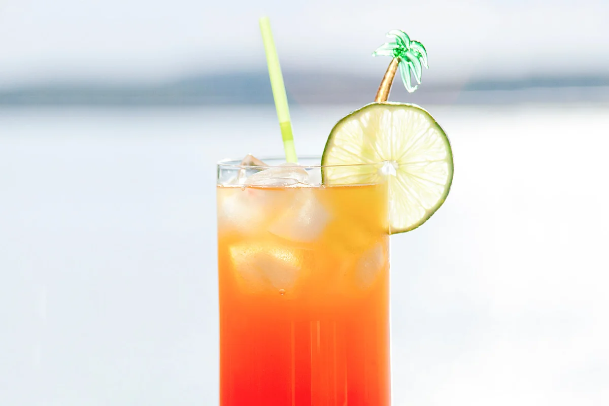tropical cocktail on a wet deck overlooking a bay of water