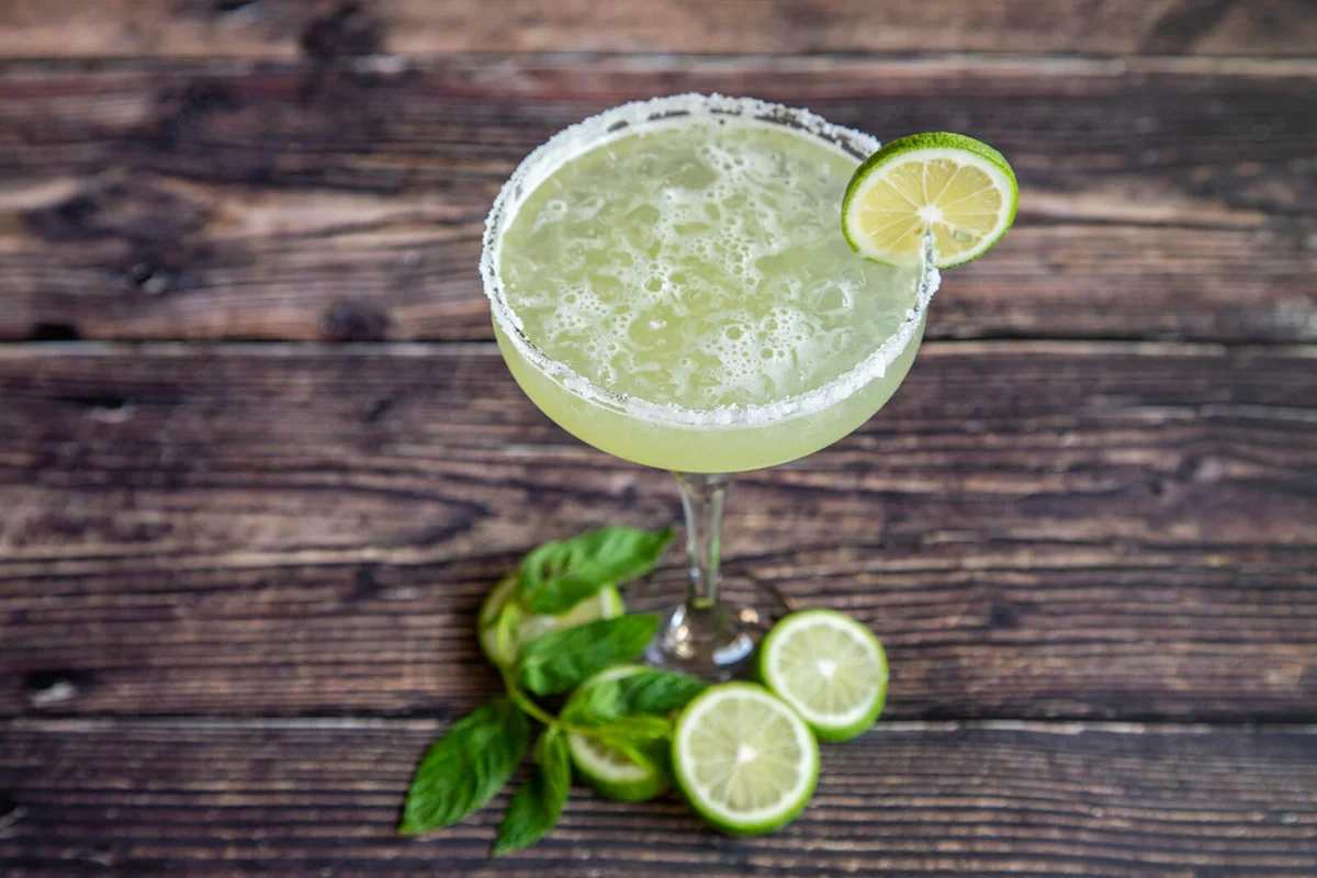 Margarita cocktail with lemon slices and mint leaf