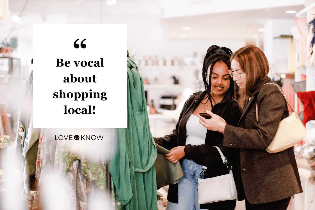 woman showing smart phone to friend in retail store