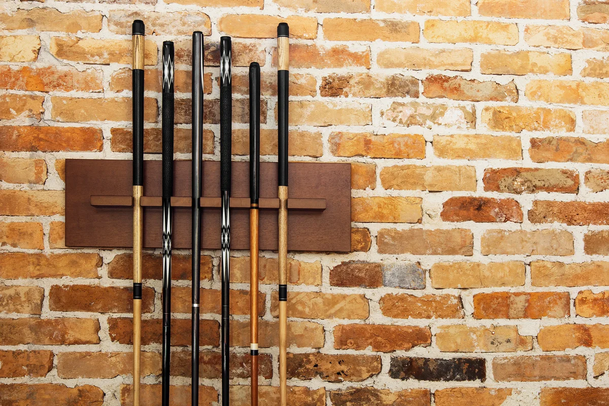 A set of snooker clubs againts a brick wall