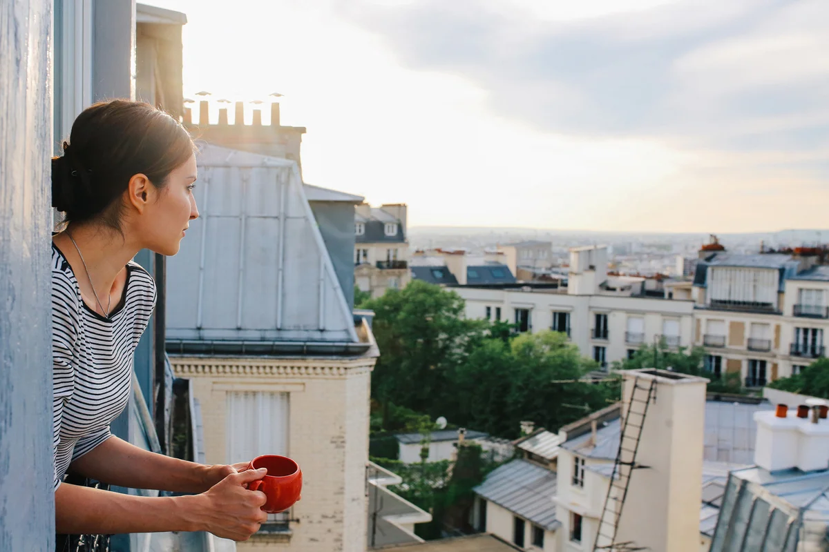 Young woman enjoying the view from a Parisian apartment