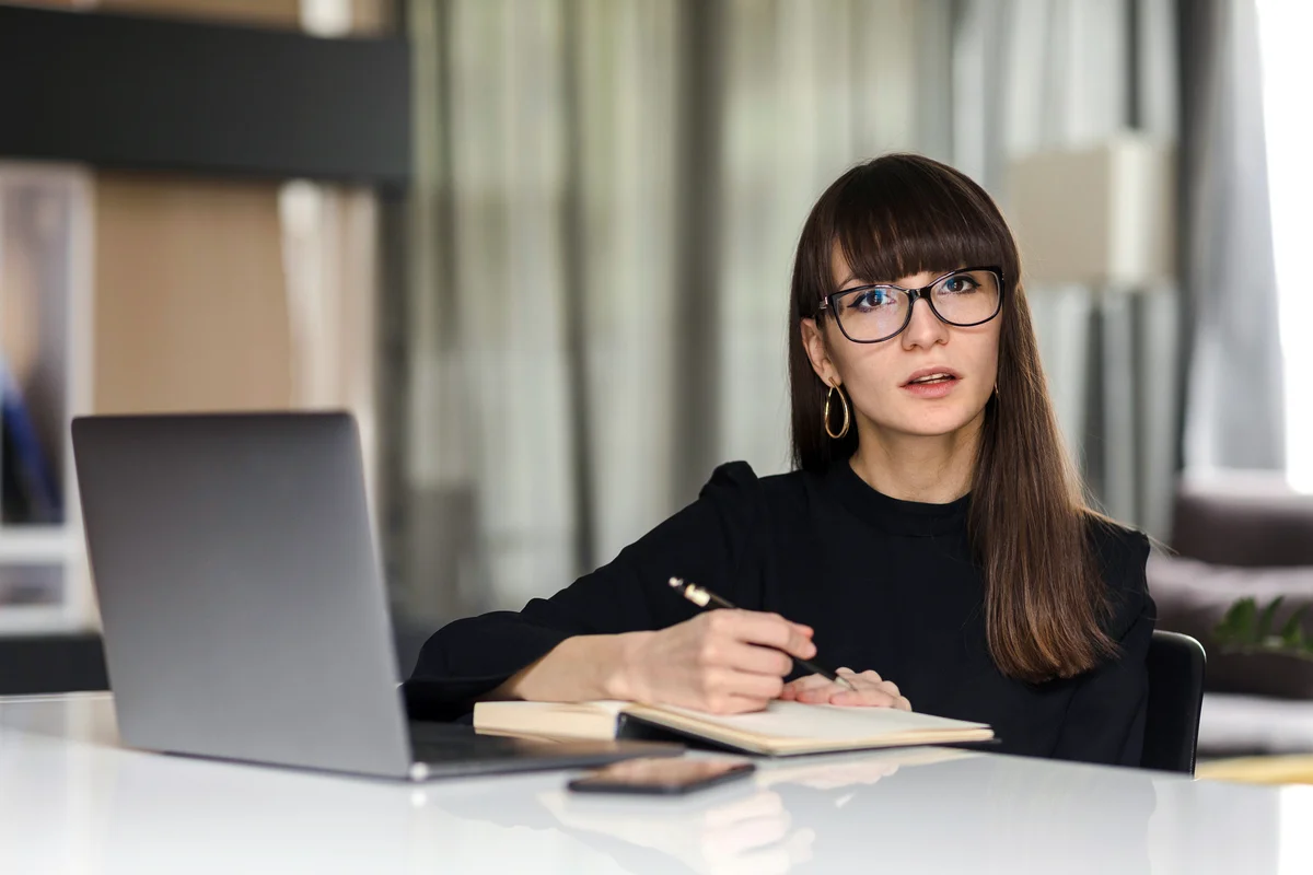 Businesswoman With Laptop Sitting At Office Desk