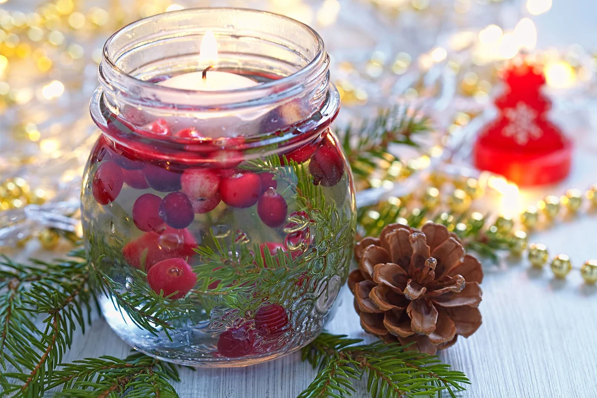 christmas decoration floating candle in jar with cranberries and greenery