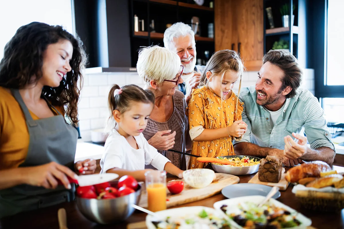 Grandparents, parents and children spending happy time in the kitchen