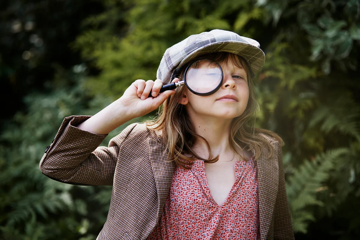 girl looking through magnifying glass
