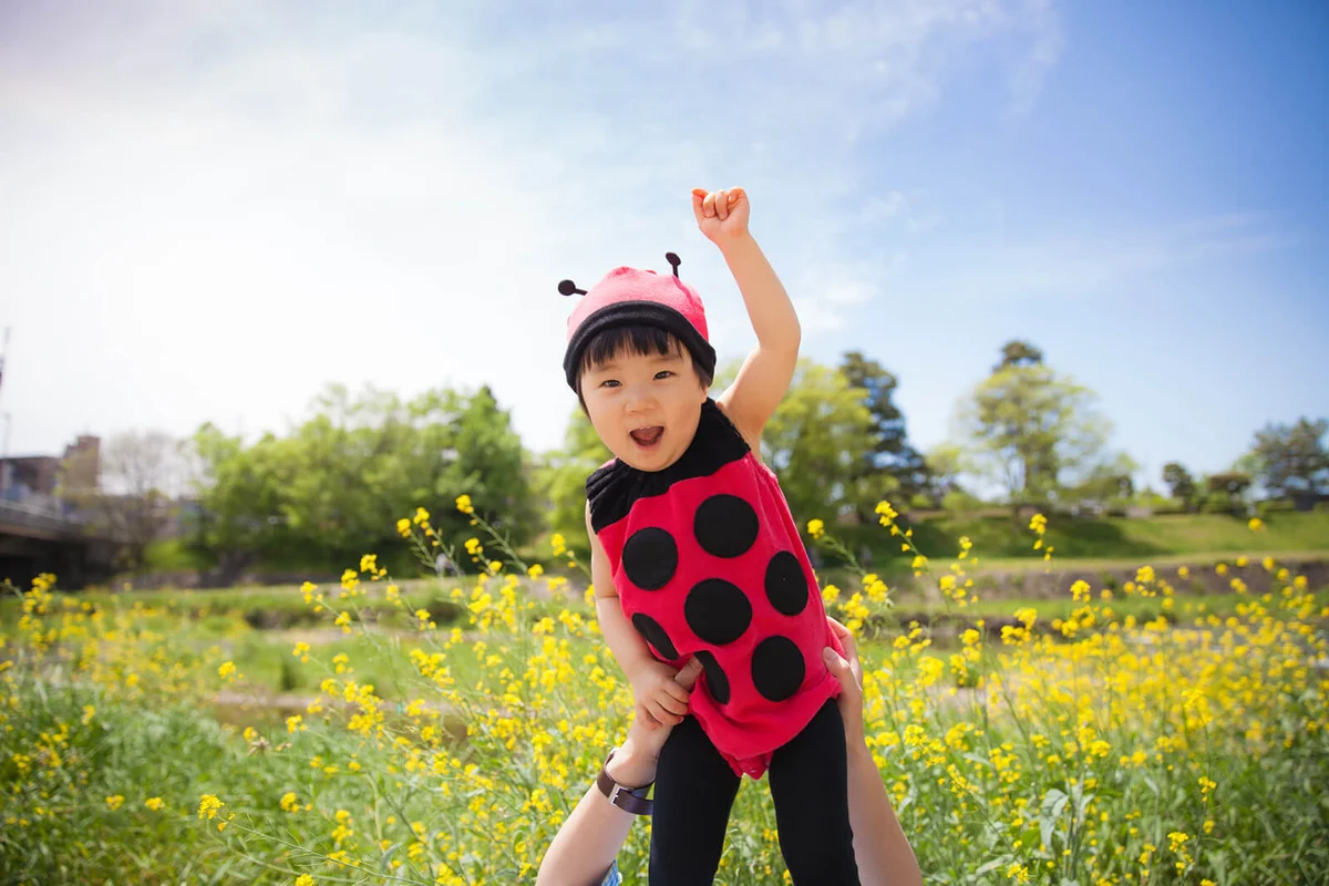girl flying over flower garden in ladybird clothing