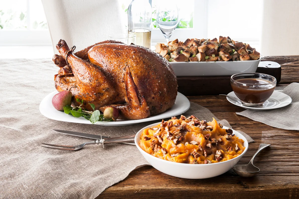 Stuffing, sweet potatoes and smoked turkey on wooden table