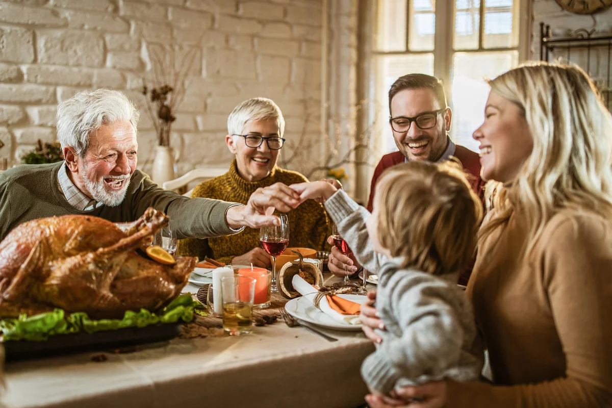 Happy extended family on Thanksgiving meal at dining table