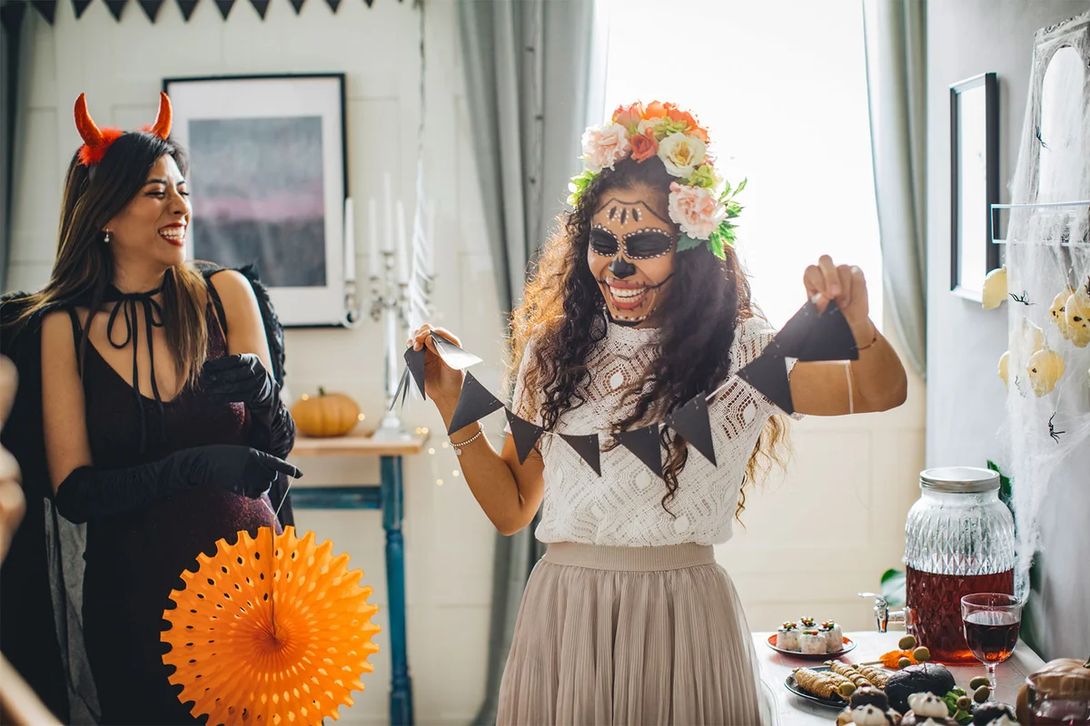 two women decorating house for halloween party