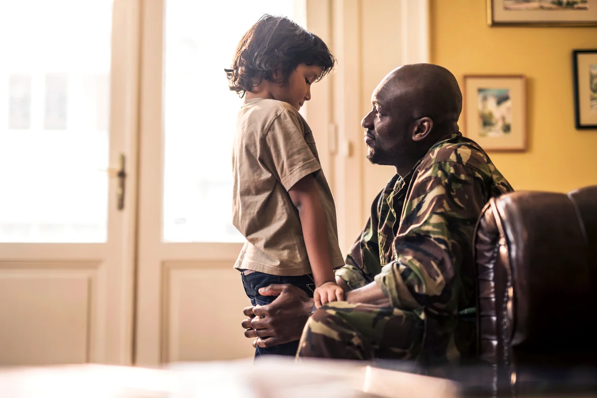 Sad boy talking to his military dad who is leaving to war
