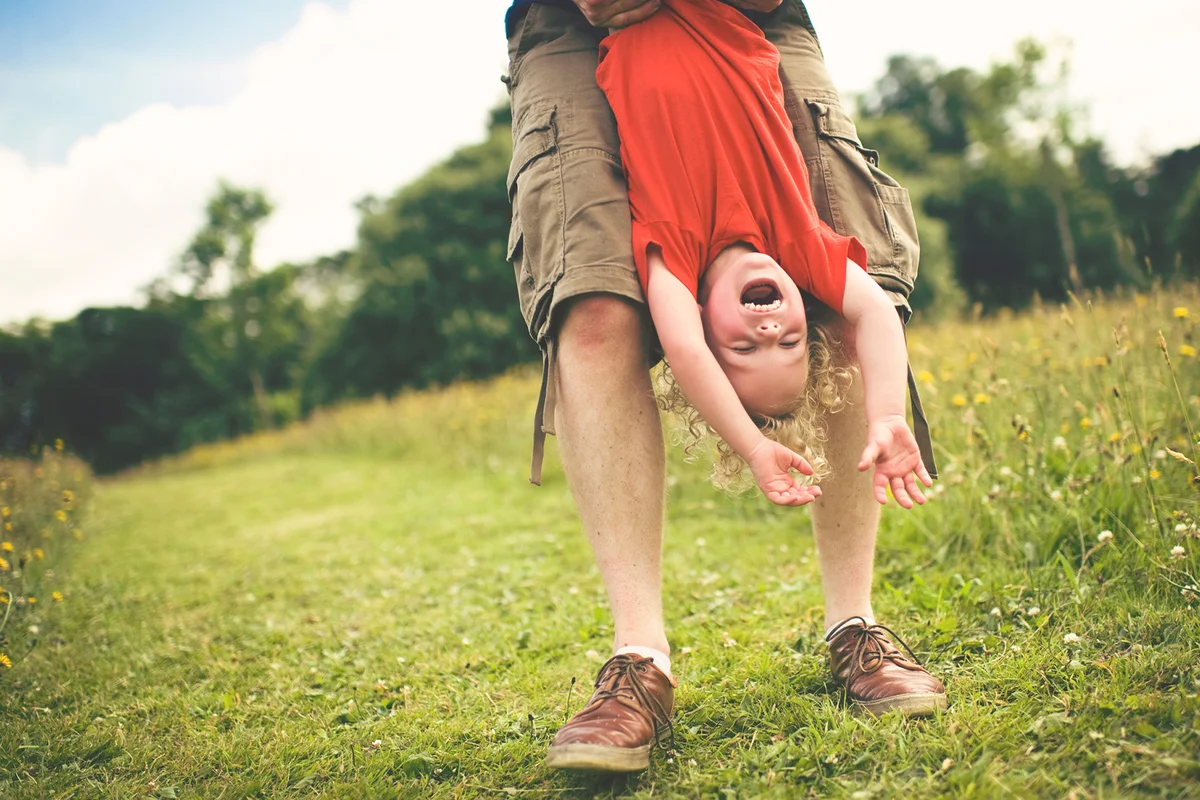 Small kid hanging upside-down and having fun