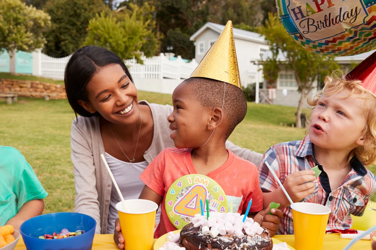 Mother With Children Enjoying Outdoor Birthday Party Together
