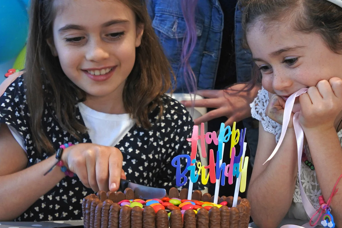 Birthday girl cutting a birthday party cake