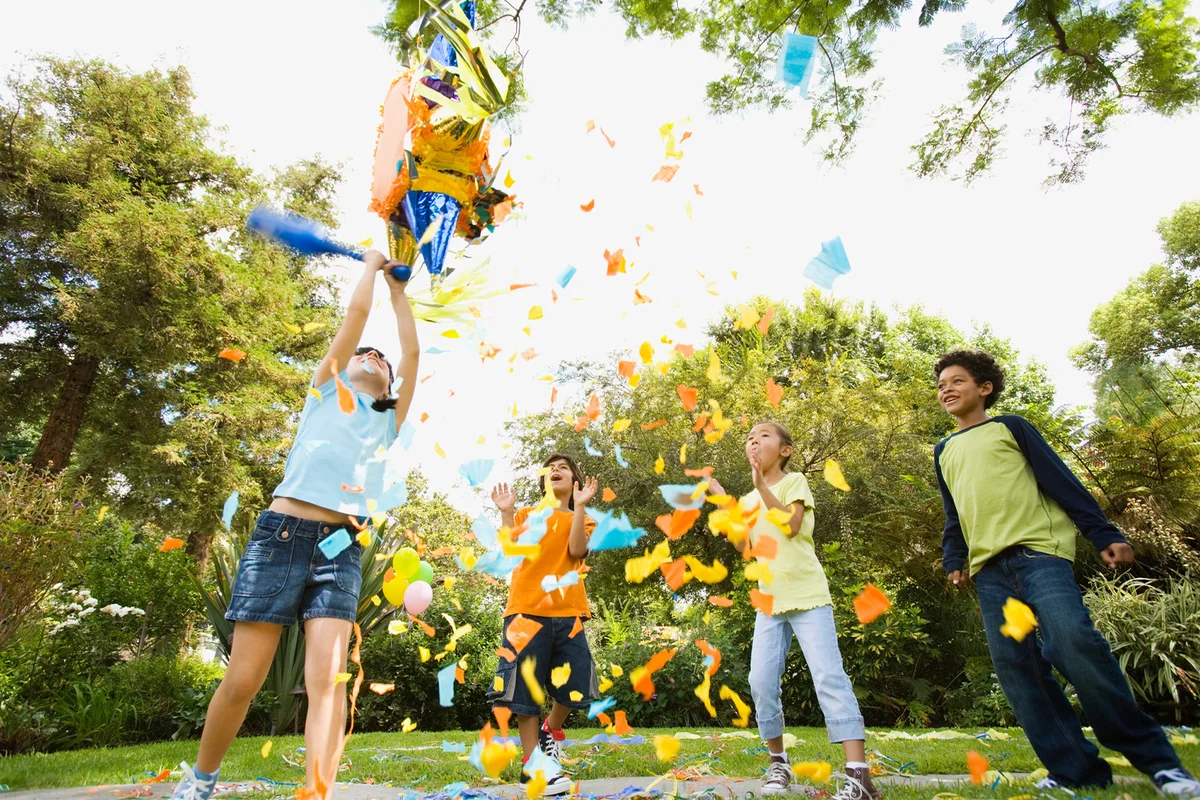 Children hitting pinata at birthday party