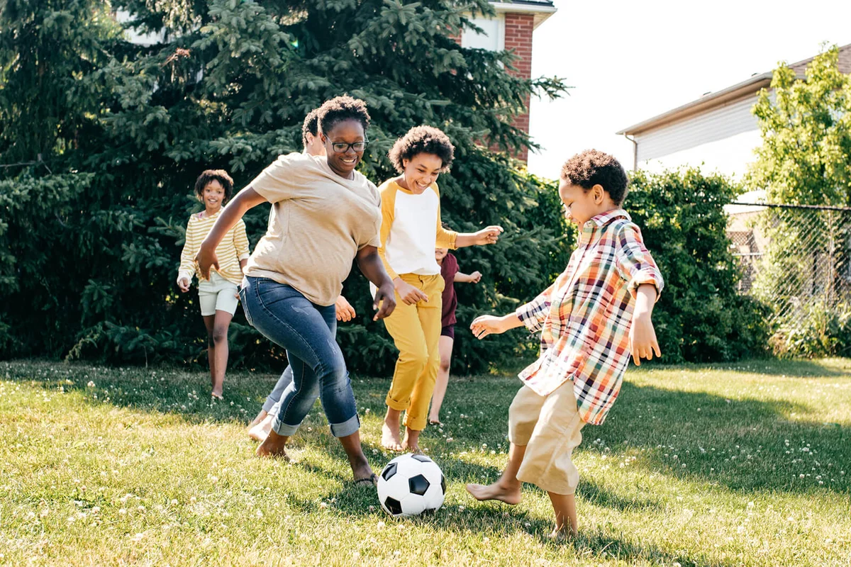 Family playing soccer in the bbackyard