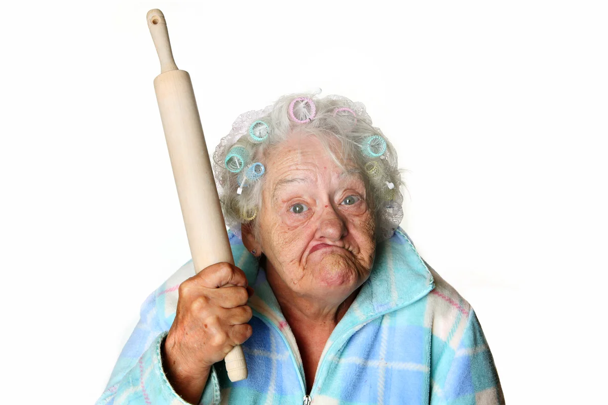 Cranky granny making faces and holding rolling pin