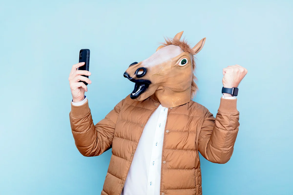 Horse man with raised fists and smart phone in hand