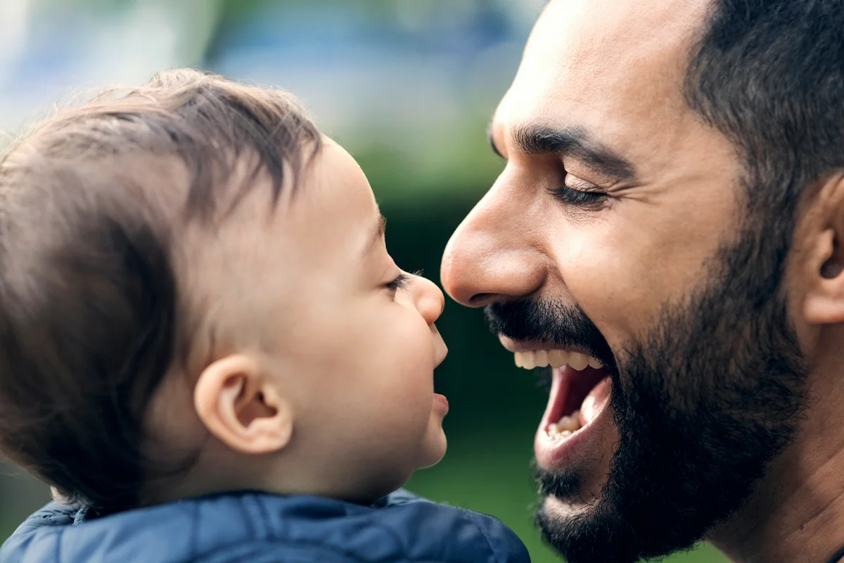 Close-up of smiling father and toddler at park