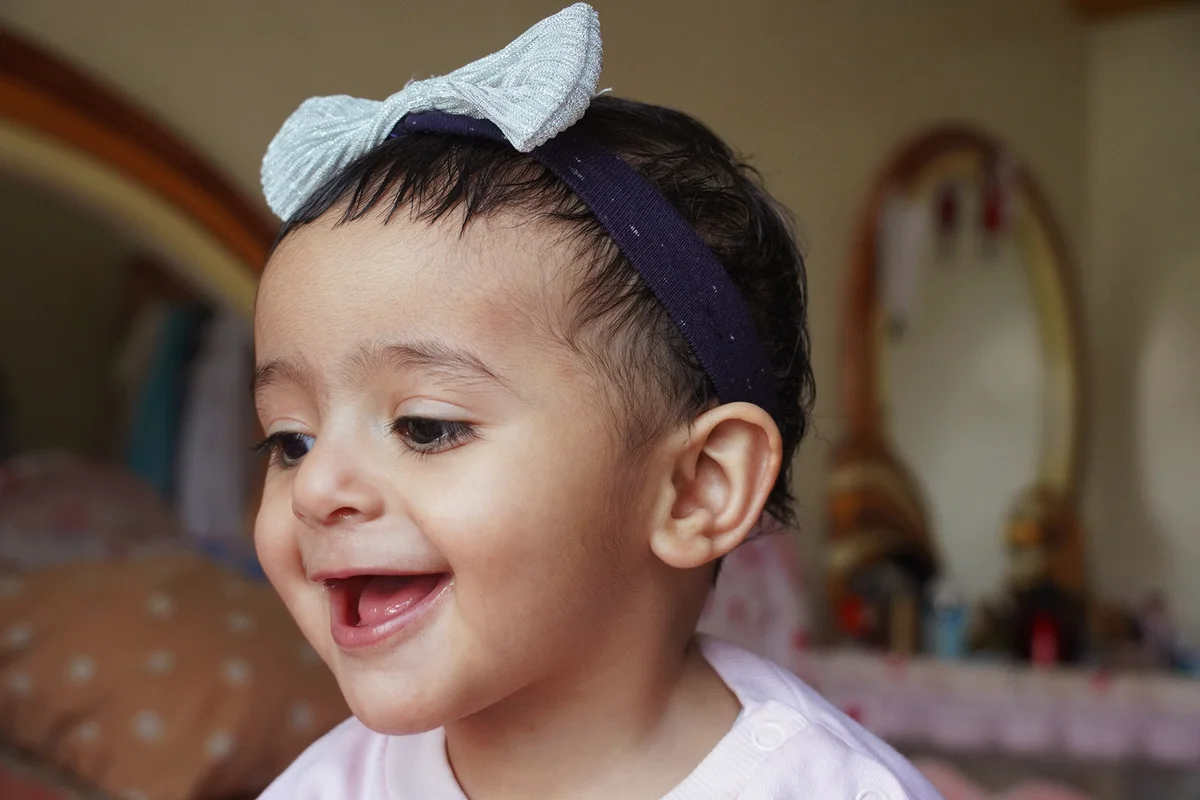 Close-Up Of Smiling Girl Looking Down At Home
