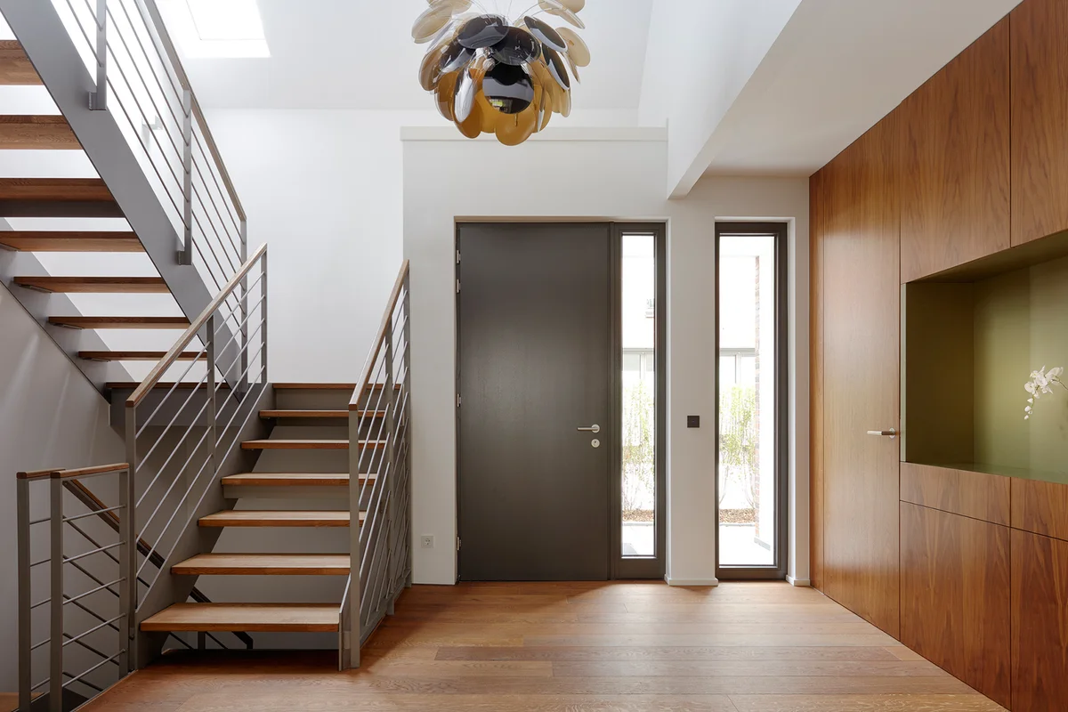 Plank floor and walnut wall covering in home near staircase