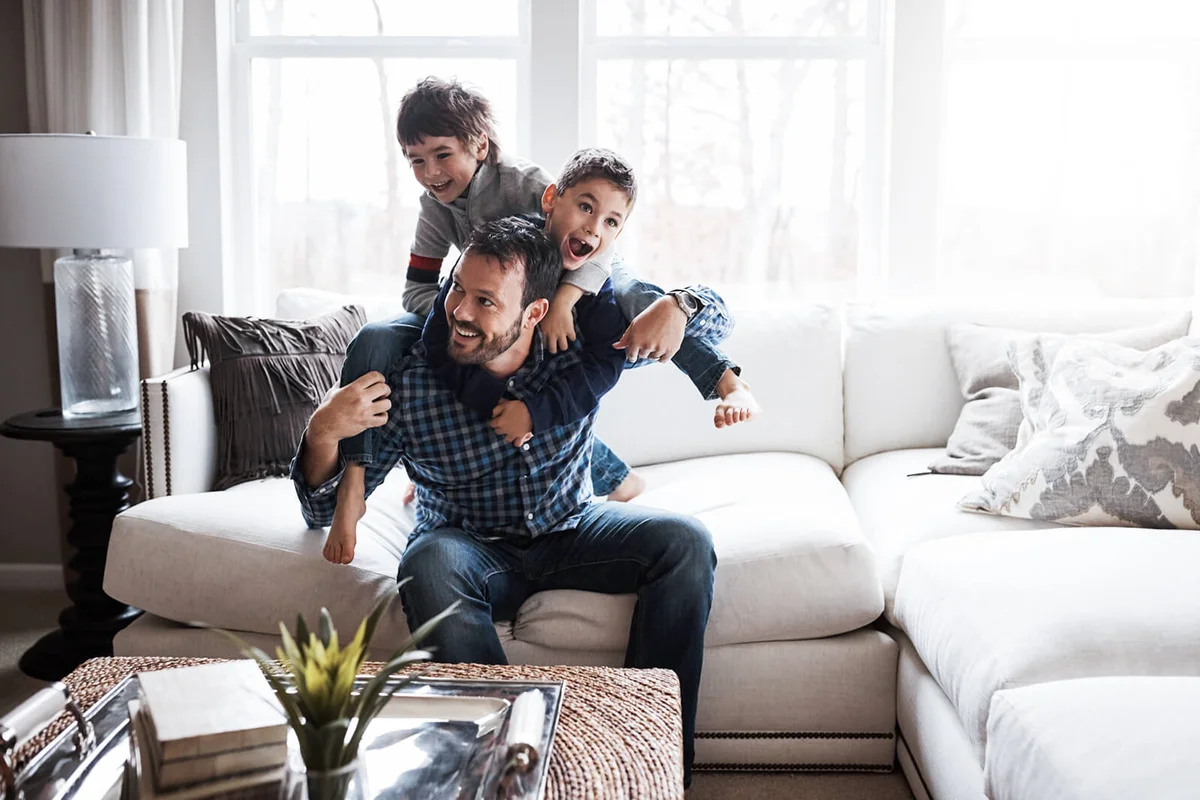 Shot of two adorable little boys having fun with their father at home