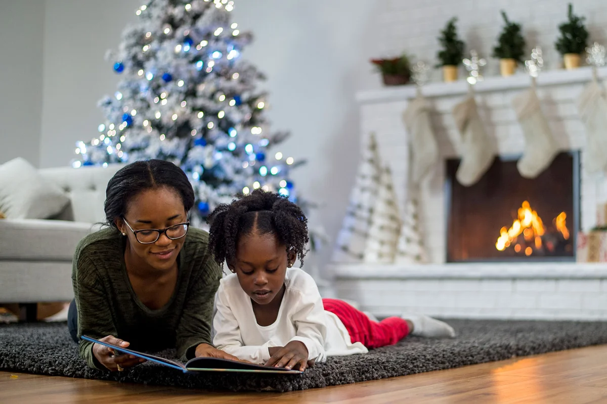 mother and daughter reading Christmas book together