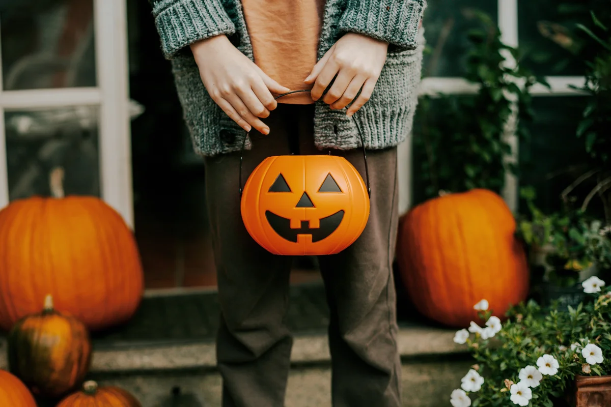 boy holding a halloween cup full of candies