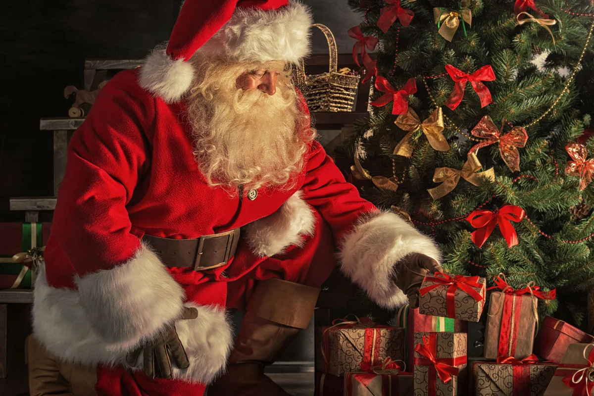 santa putting presents under tree