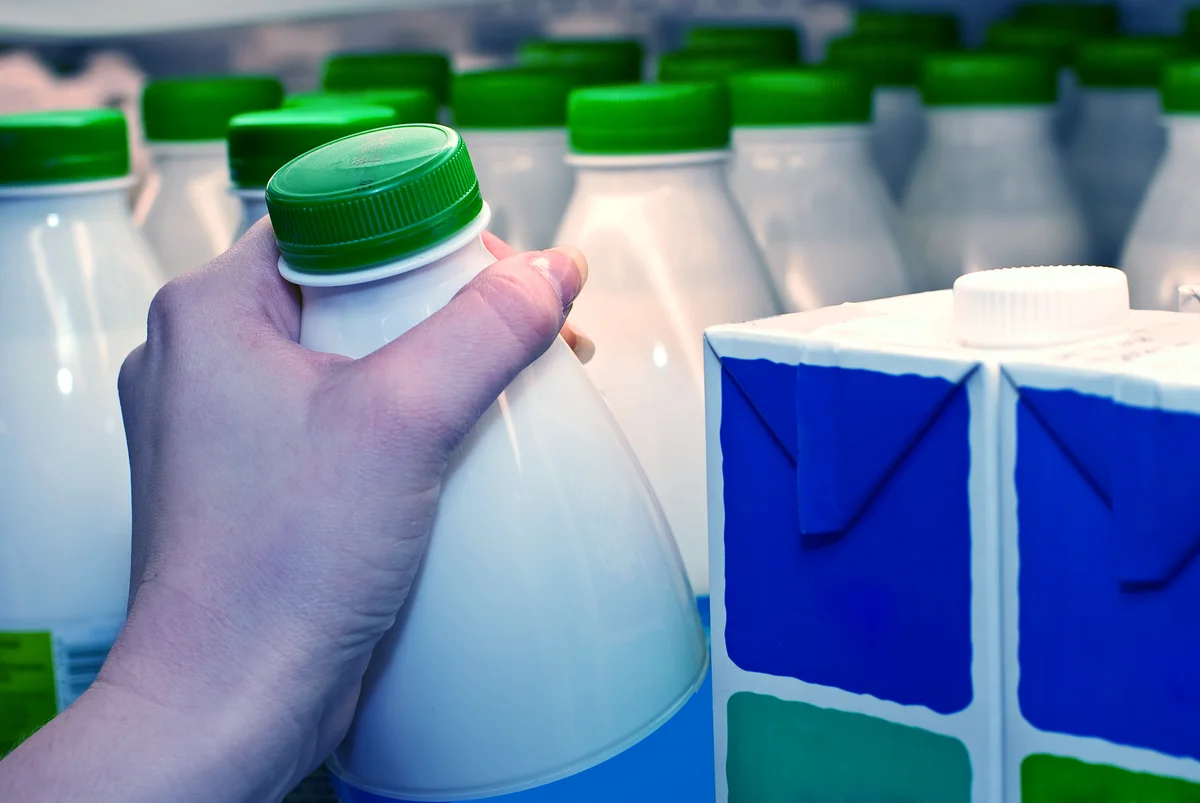 Hand grabbing milk bottle